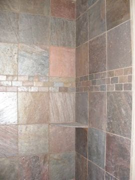 A tiled shower with a mosaic tile pattern.