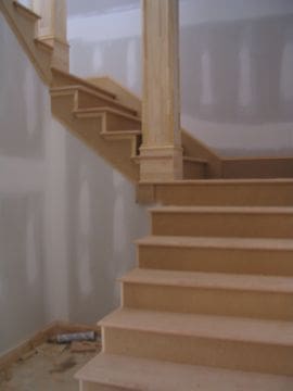 A staircase with wooden steps and white walls.